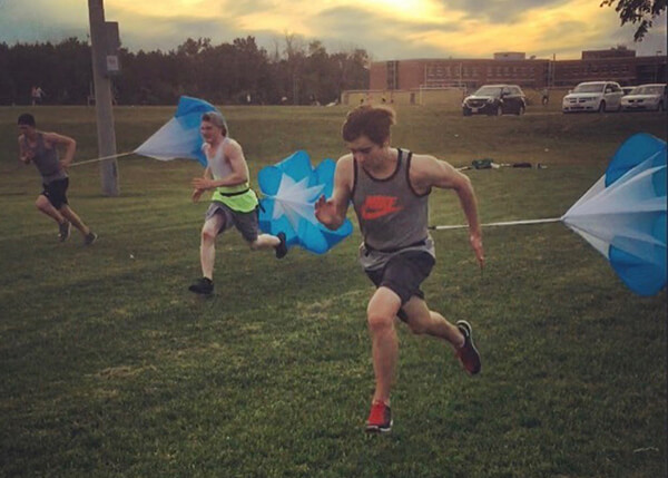 An image of athletes running with parachutes