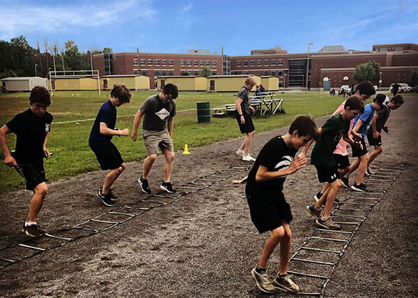 An image of youth athletes doing ladder quick feet drills